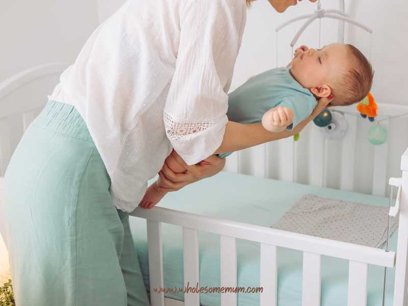 mom-carrying-a-sleeping-baby-to-cot-after-sleep-training